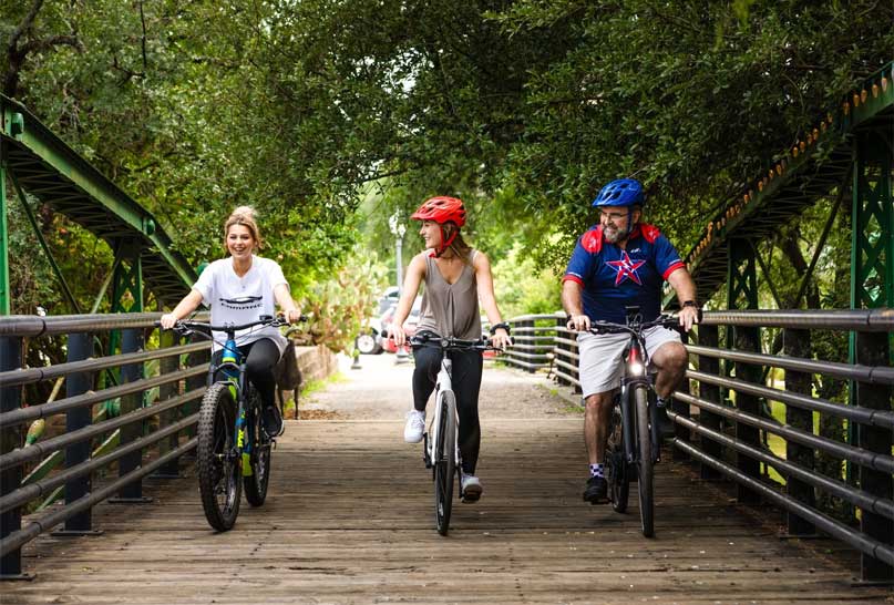 bicyclists crossing a wooden bridge